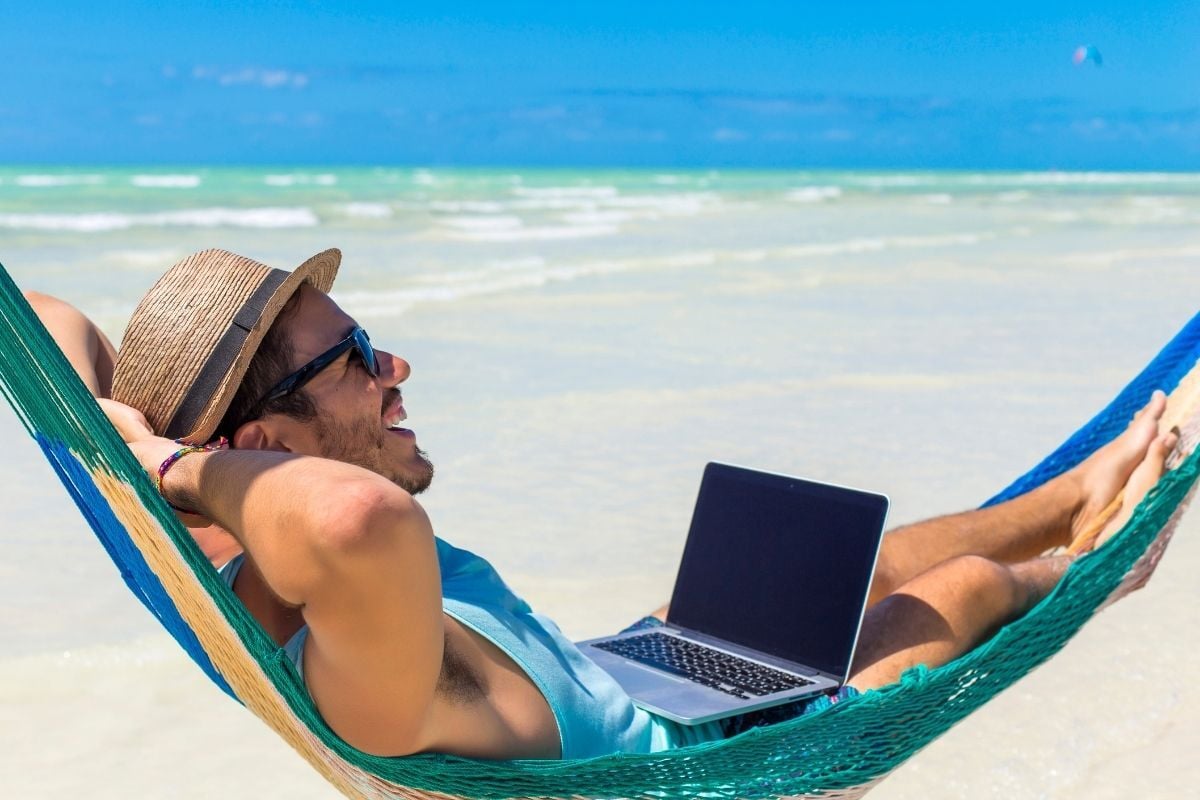 Ondernemer met laptop in hangmat tijdens vakantie