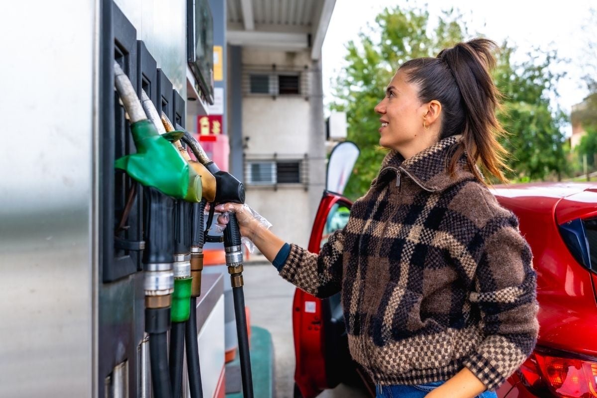 Vrouwelijke zzp'er tankt voor een zakelijke rit naar een opdrachtgever