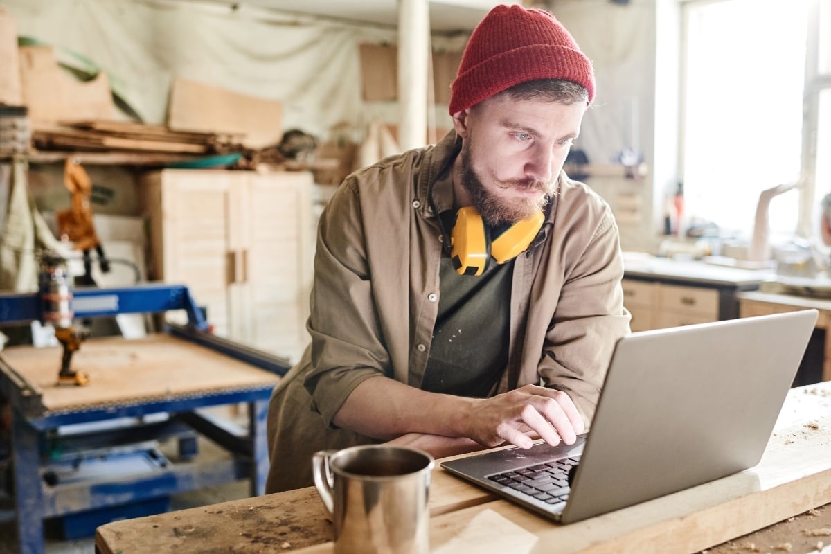 Man achter laptop op een werkplaats 