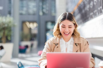 Blije vrouw achter laptop