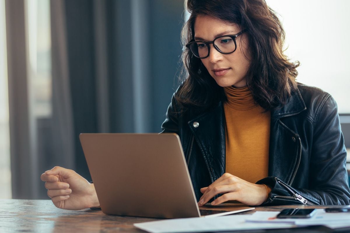 Vrouw met bril die gespannen naar computer kijkt