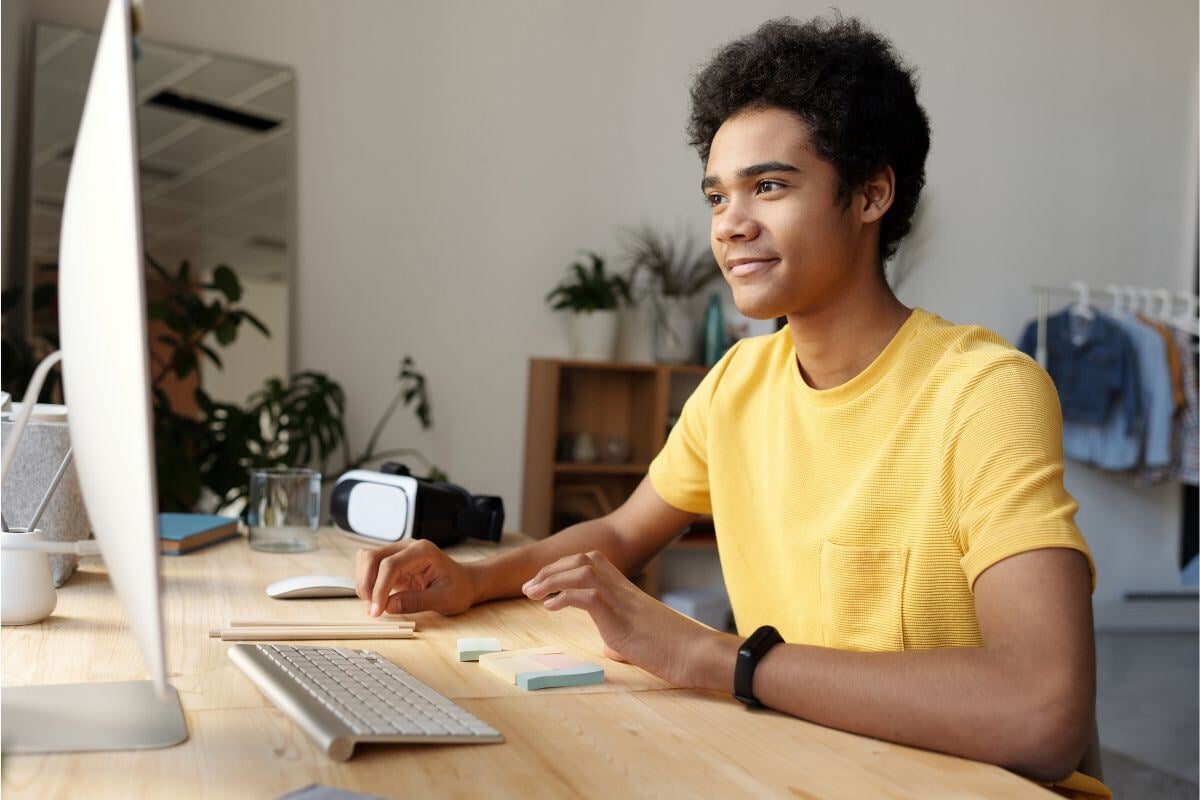 Man in geel shirt achter een computer