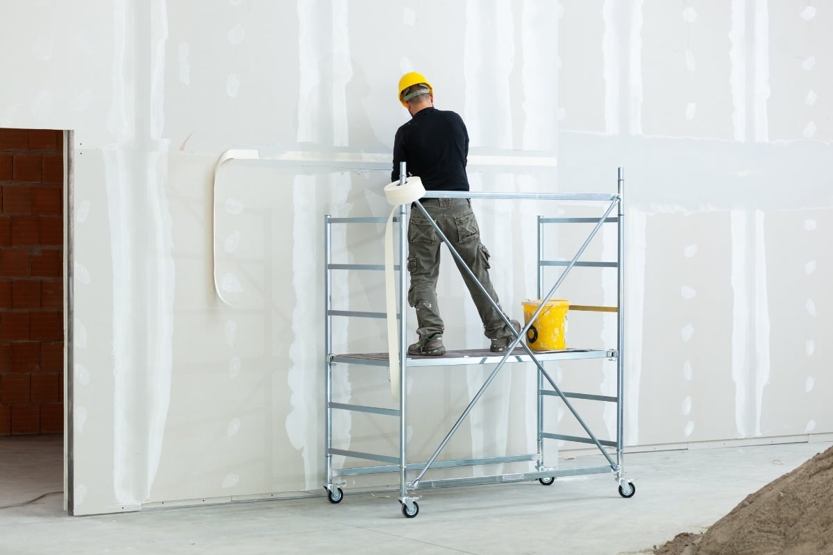 Bouwvakker op een steiger aan het werk