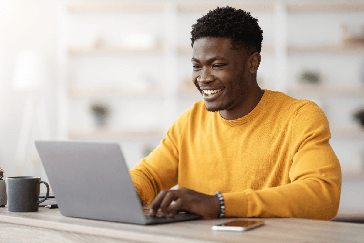 lachende man achter laptop