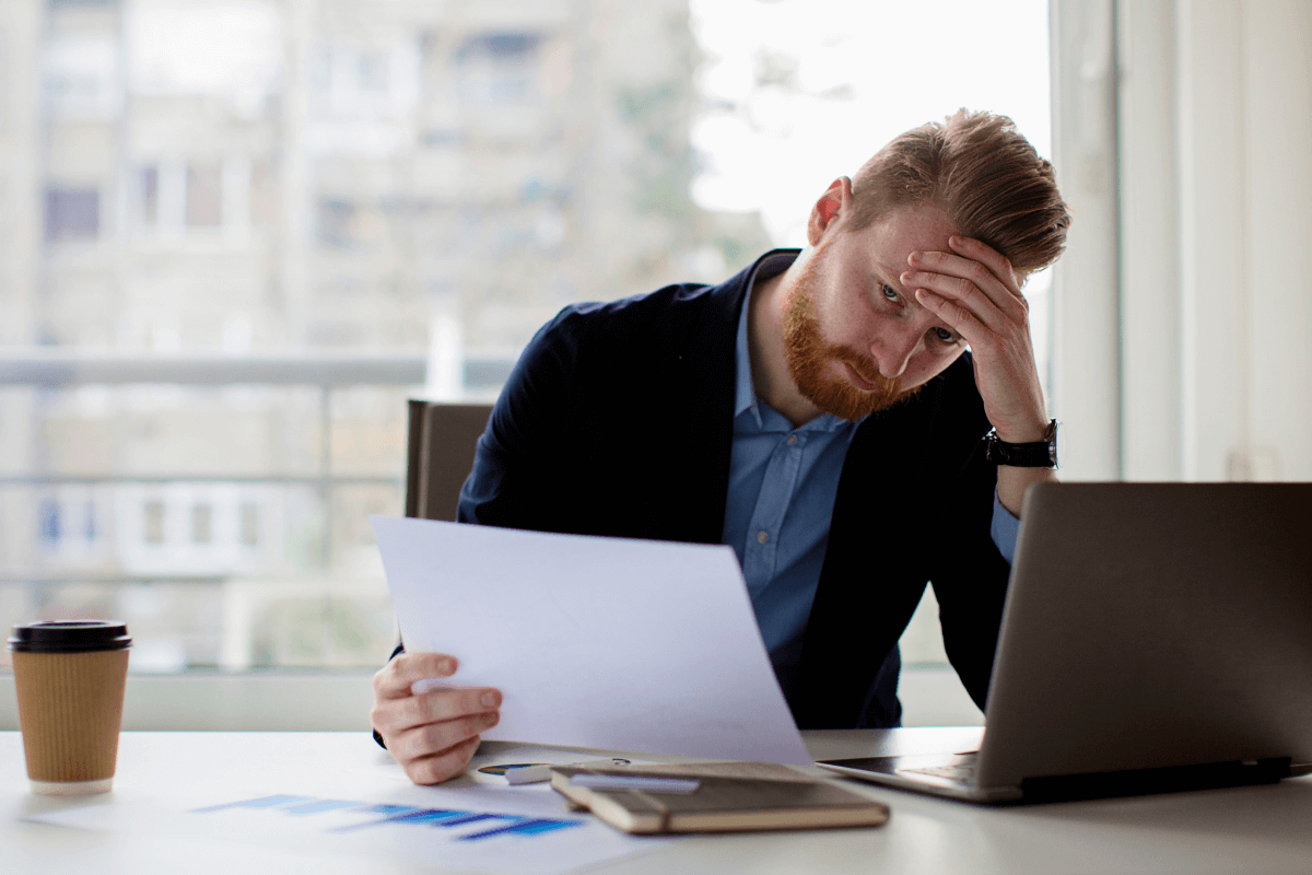 man met imposter syndrome achter bureau