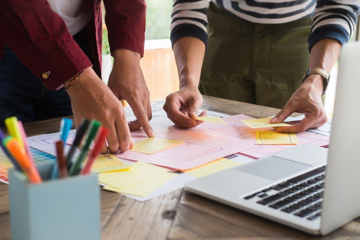 twee mensen die post-its aan het plakken zijn 